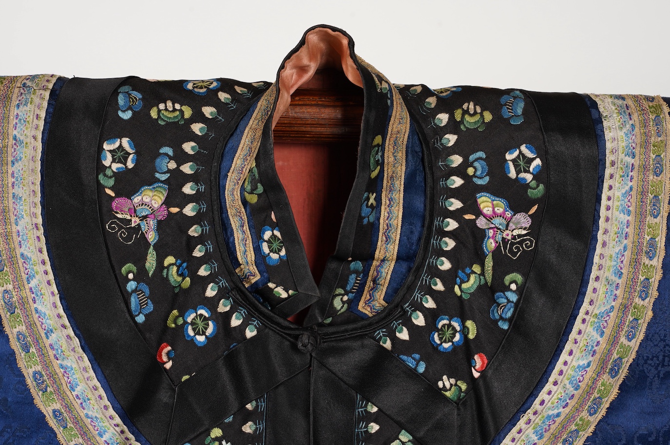 A late 19th century Chinese blue silk damask jacket, woven with Phoenix and auspicious symbols. The jacket edged with ornate rows of braiding and silk embroidery, the interior with original pink silk lining. The jacket f